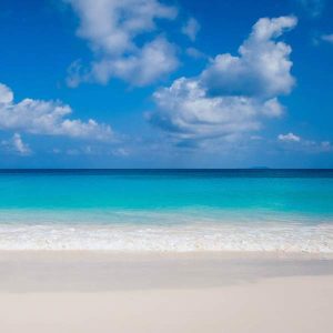 white sandy beach with turquoise sea and blue sky