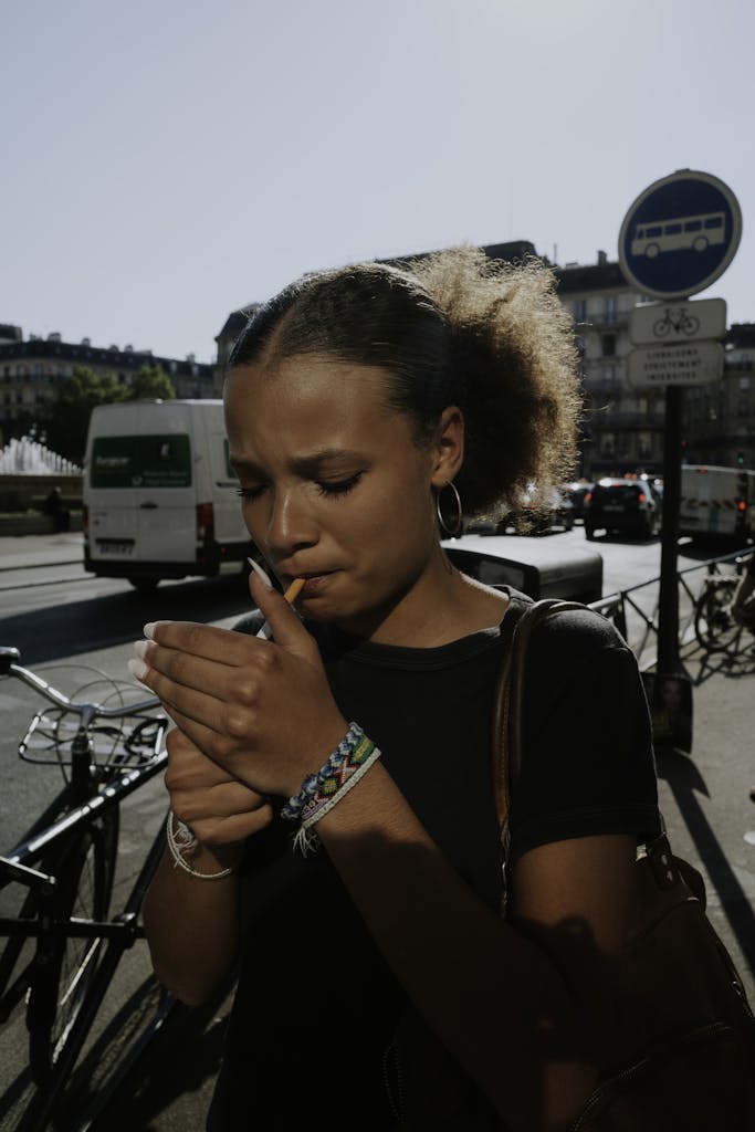 Woman Lighting Cigarette on Bus Stop